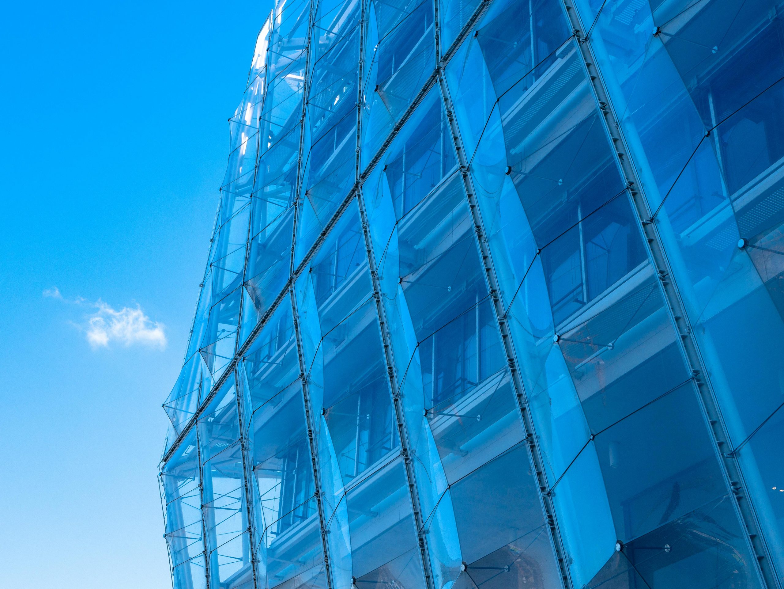 Striking facade of modern glass architecture in Hamburg against a clear blue sky.